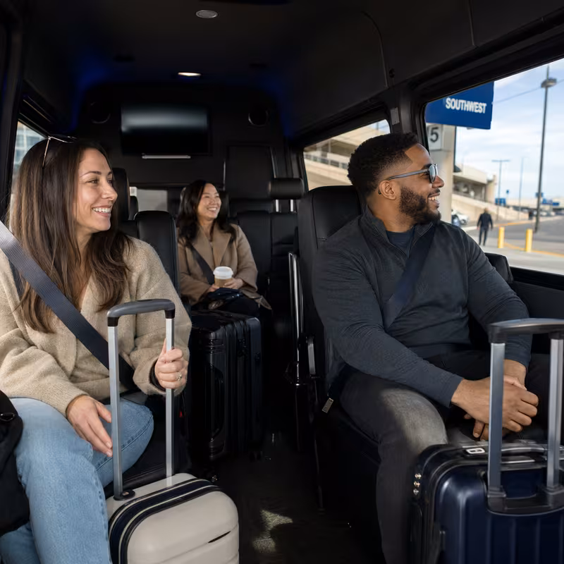 Passengers loading luggage while boarding an Garland group shuttle
