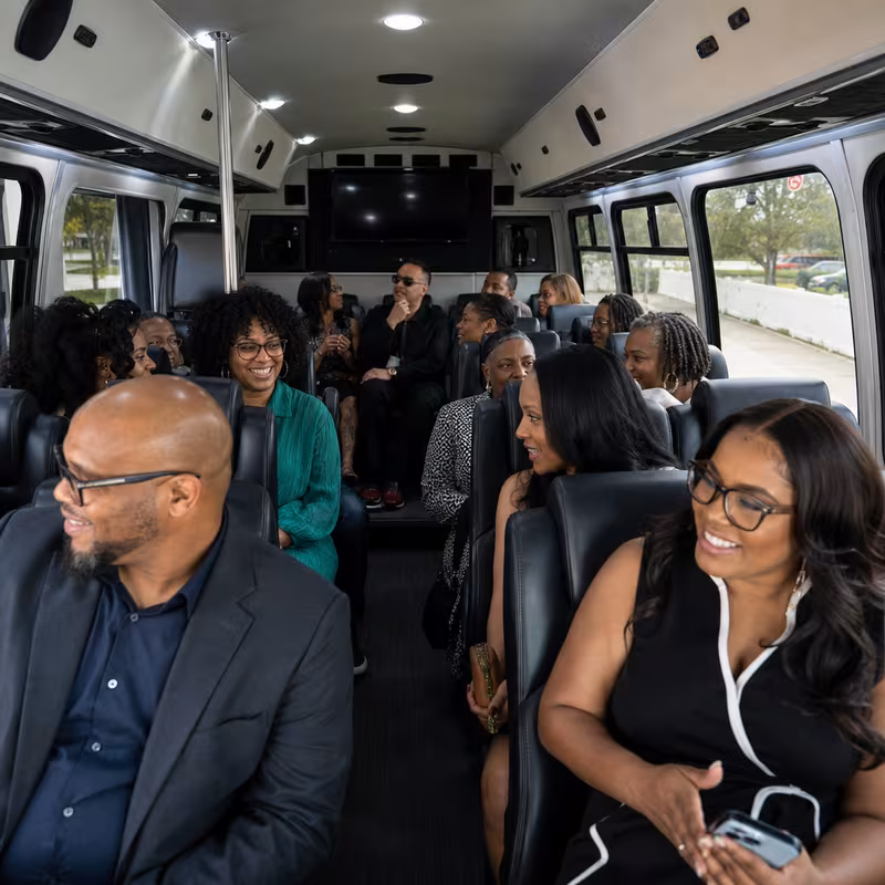 Group boarding a white charter bus for Private Event Transportation transportation in Garland