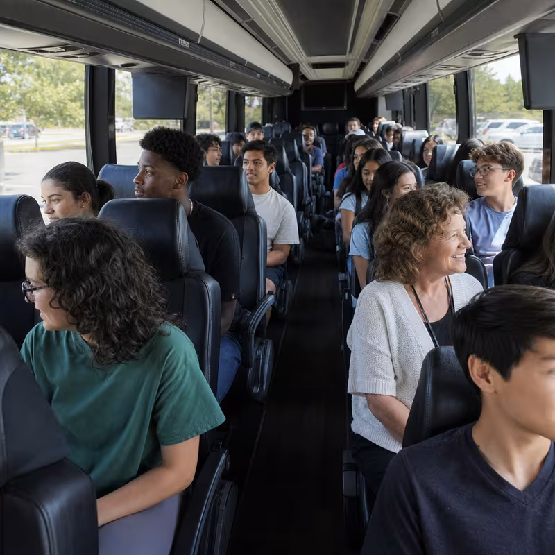 Group boarding a white charter bus for School Transportation transportation in Garland