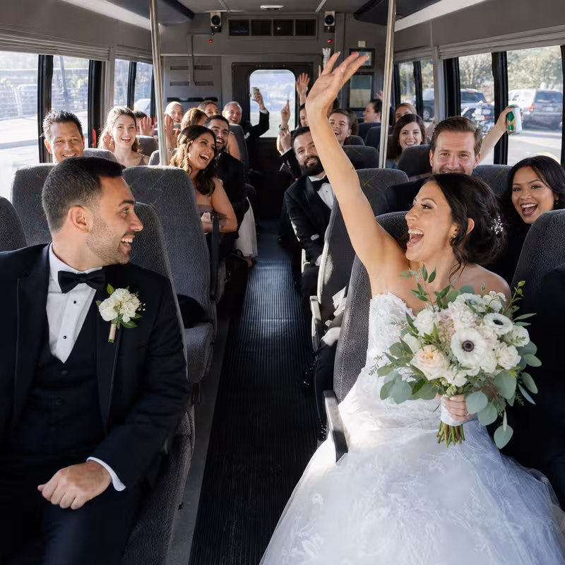 Group boarding a white charter bus for Wedding Transportation transportation in Garland