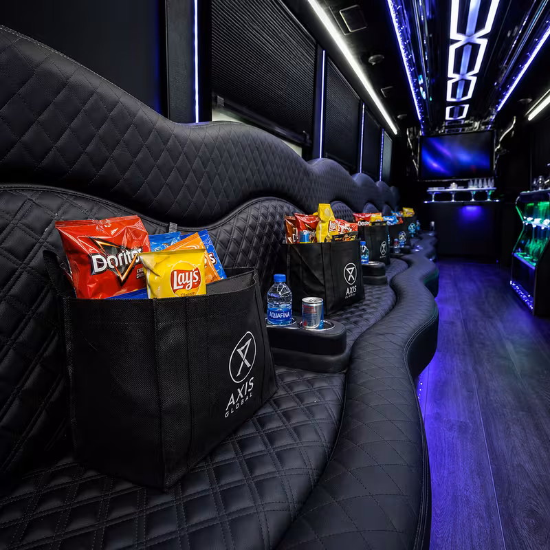 Party bus interior with wraparound leather seating and LED lighting in Garland